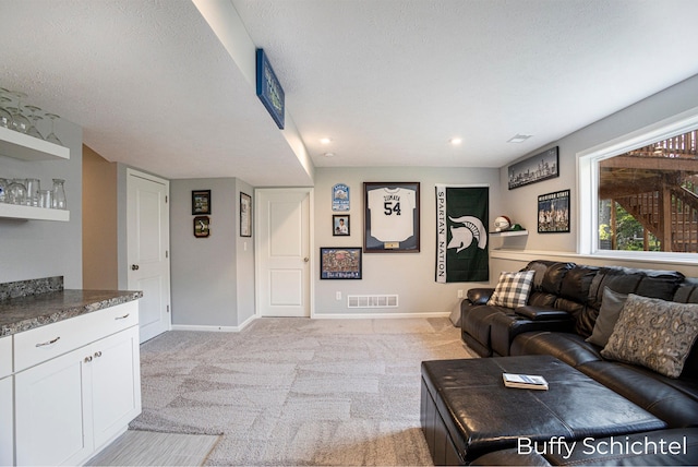 living room featuring light carpet and a textured ceiling