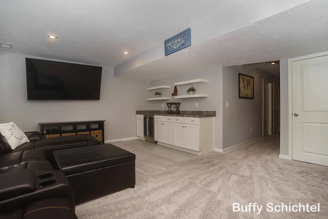 carpeted living room with beverage cooler and a textured ceiling