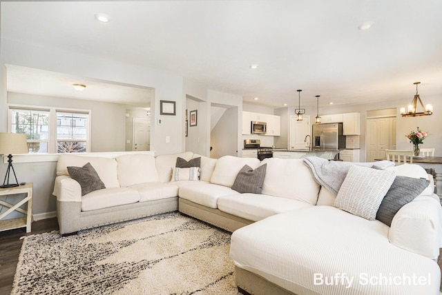 living room featuring sink, a notable chandelier, and hardwood / wood-style floors