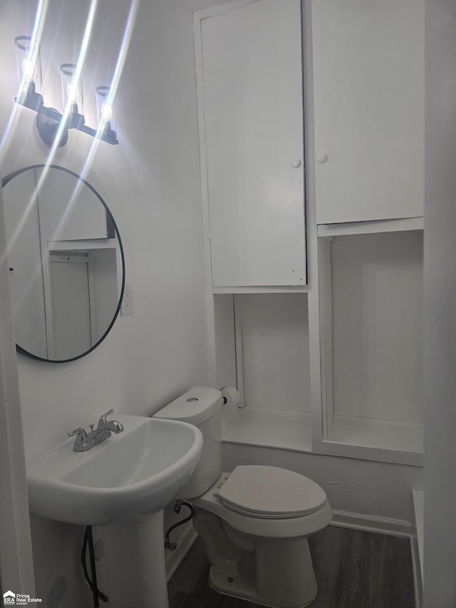 bathroom featuring hardwood / wood-style flooring and toilet