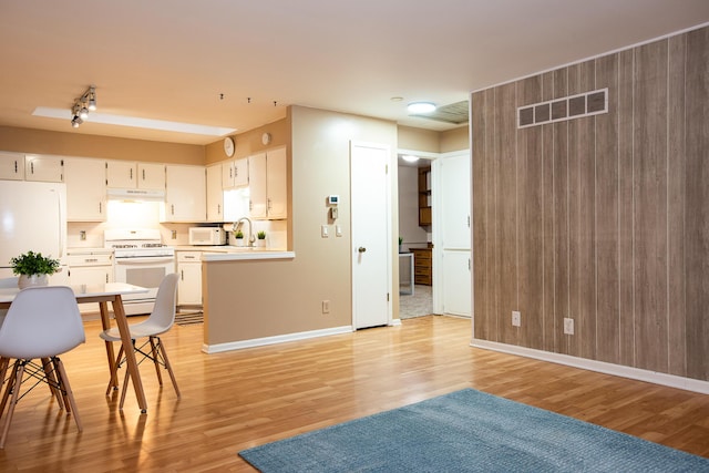 kitchen featuring sink, white cabinets, white appliances, and light hardwood / wood-style floors