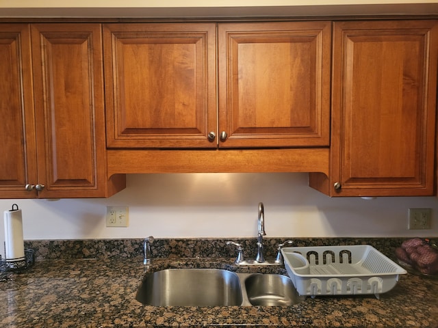 interior details with dark stone countertops and sink