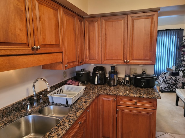 kitchen featuring sink and dark stone countertops