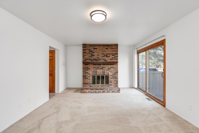 unfurnished living room with carpet flooring, a brick fireplace, and visible vents