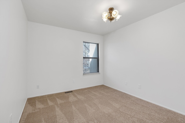 unfurnished room with visible vents, baseboards, and carpet