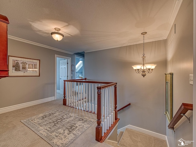 stairs with ornamental molding, carpet floors, a notable chandelier, and a textured ceiling