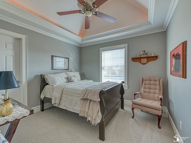 carpeted bedroom with a raised ceiling, ornamental molding, and ceiling fan