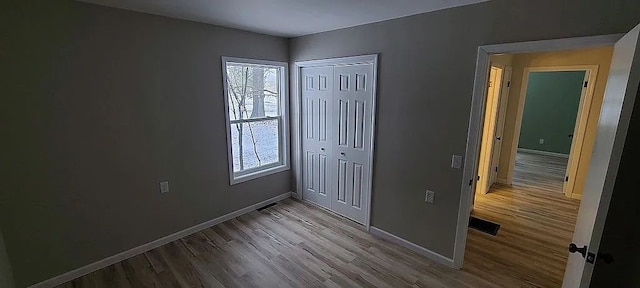 unfurnished bedroom with light hardwood / wood-style floors and a closet