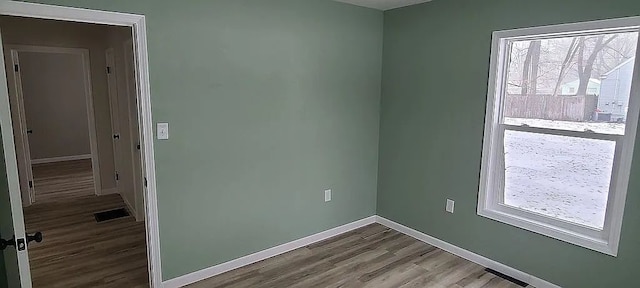 unfurnished room with wood-type flooring