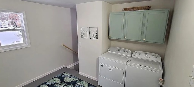 clothes washing area with cabinets and separate washer and dryer