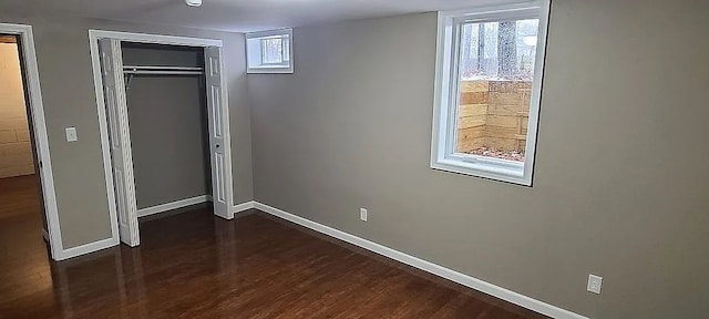 unfurnished bedroom with dark hardwood / wood-style flooring and a closet