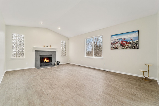 unfurnished living room with wood-type flooring, lofted ceiling, and a fireplace