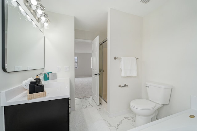 bathroom featuring vanity, a shower with shower door, and toilet