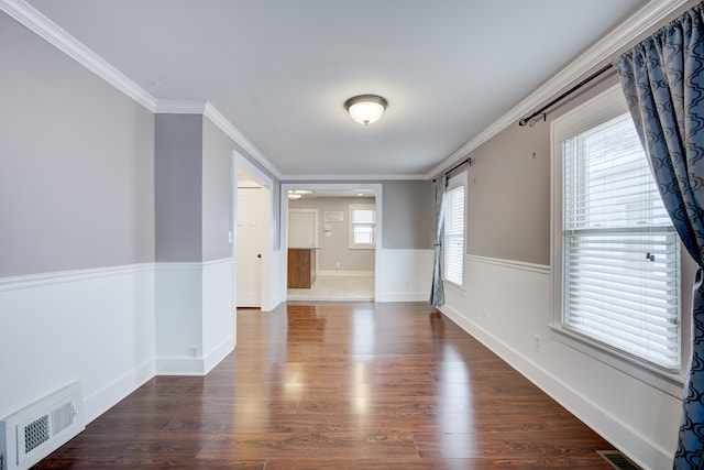 spare room with crown molding, a barn door, and dark hardwood / wood-style flooring