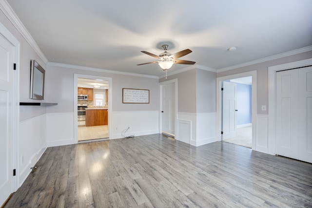 unfurnished living room featuring light hardwood / wood-style flooring, ornamental molding, and ceiling fan