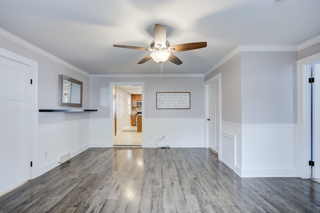 empty room featuring hardwood / wood-style flooring, ornamental molding, and ceiling fan