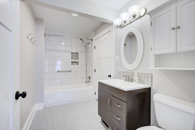 full bathroom with tiled shower / bath, vanity, toilet, and decorative backsplash