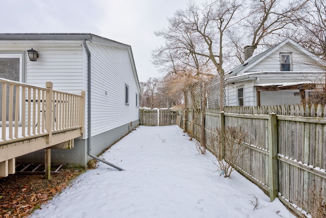 snowy yard featuring a wooden deck