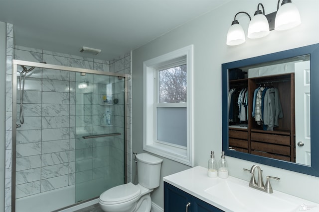 bathroom with vanity, a shower with shower door, and toilet