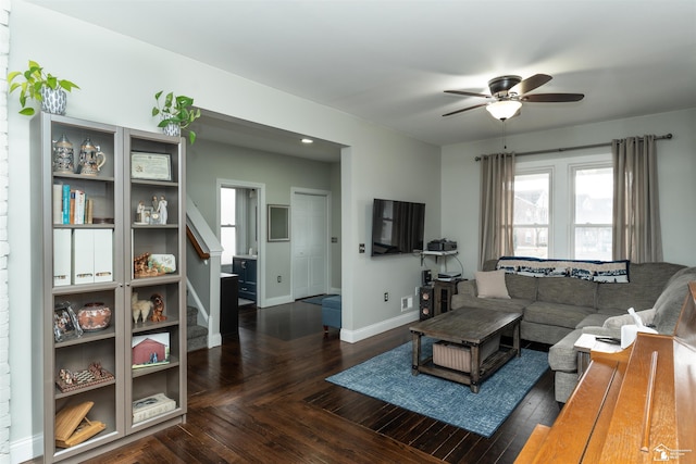 living room featuring ceiling fan and dark hardwood / wood-style floors