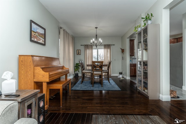 dining space with dark wood-type flooring and a chandelier