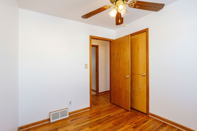 unfurnished bedroom with ceiling fan, a closet, and light wood-type flooring