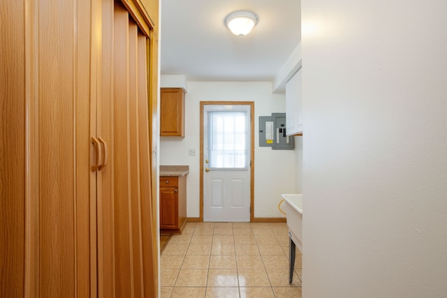 doorway to outside featuring electric panel and light tile patterned floors