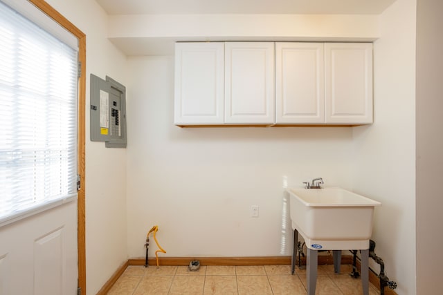 laundry room featuring electric panel, sink, and light tile patterned floors