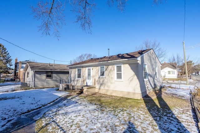 snow covered back of property with central AC