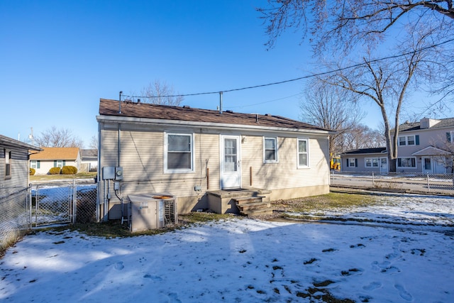 snow covered rear of property with cooling unit