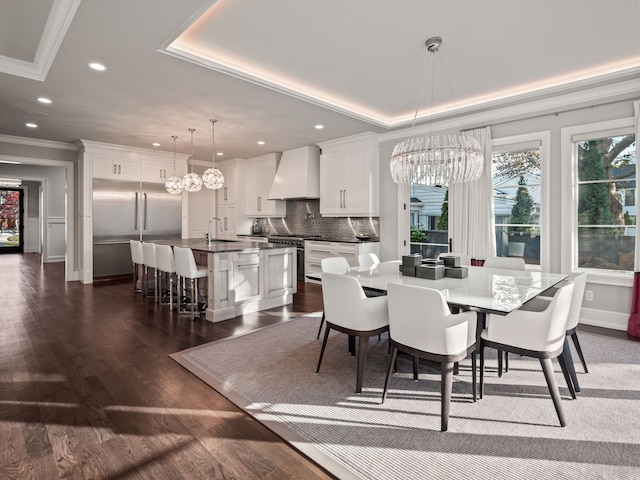 dining area with dark wood-style floors, crown molding, a raised ceiling, and a notable chandelier