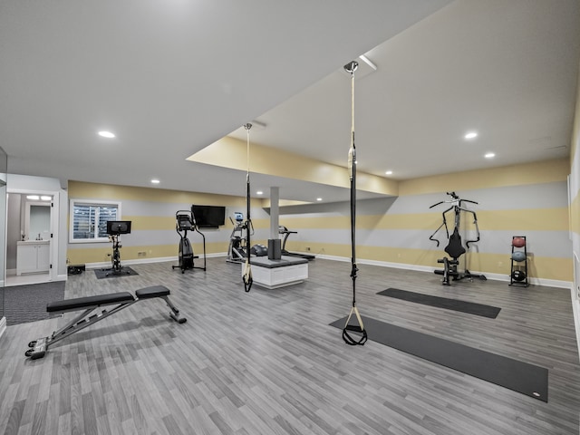 exercise room with light wood-style floors, recessed lighting, and baseboards