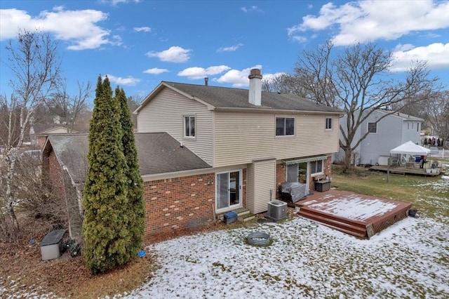 snow covered property with cooling unit and a deck