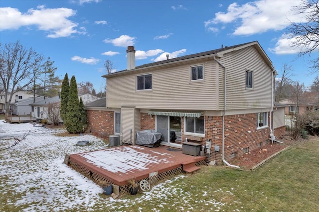 snow covered property with a wooden deck, a lawn, and central air condition unit