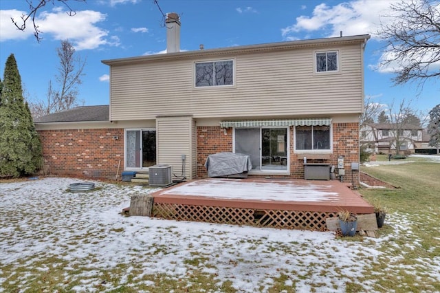 snow covered property with a wooden deck and cooling unit