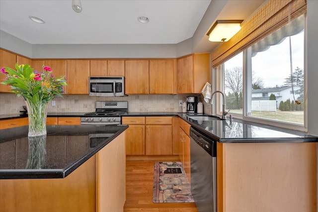 kitchen featuring sink, decorative backsplash, light hardwood / wood-style flooring, and stainless steel appliances