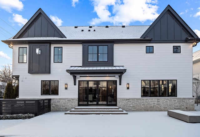 view of snow covered back of property