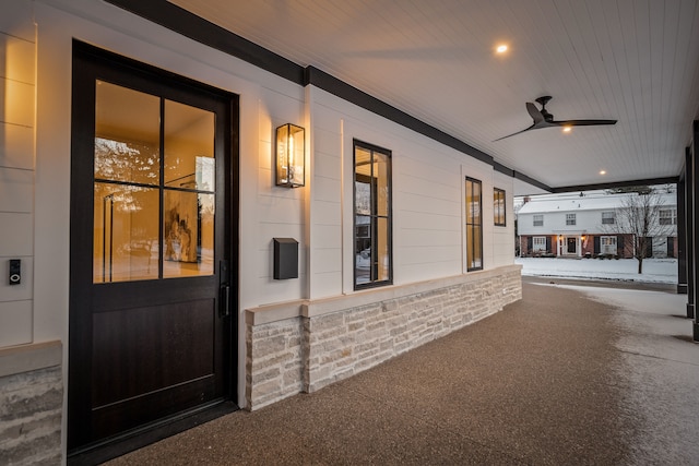 view of exterior entry featuring ceiling fan and covered porch