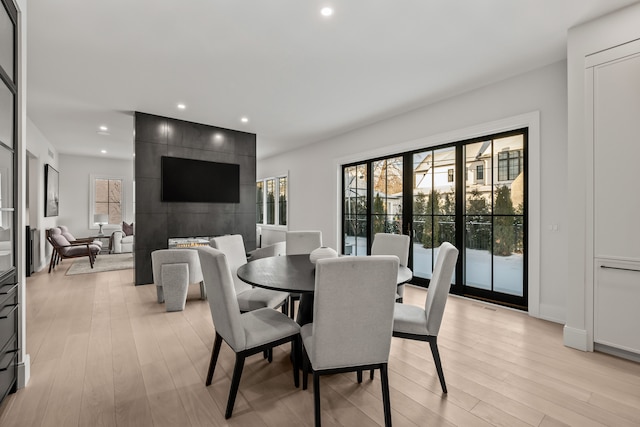 dining space with a healthy amount of sunlight and light hardwood / wood-style floors