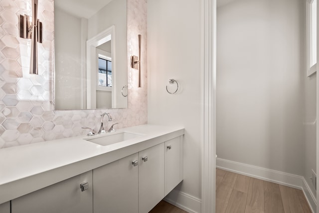 bathroom with hardwood / wood-style flooring, vanity, and decorative backsplash