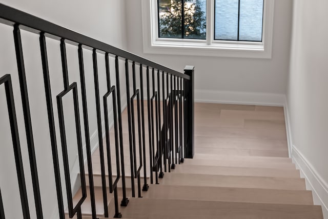 stairs featuring hardwood / wood-style floors