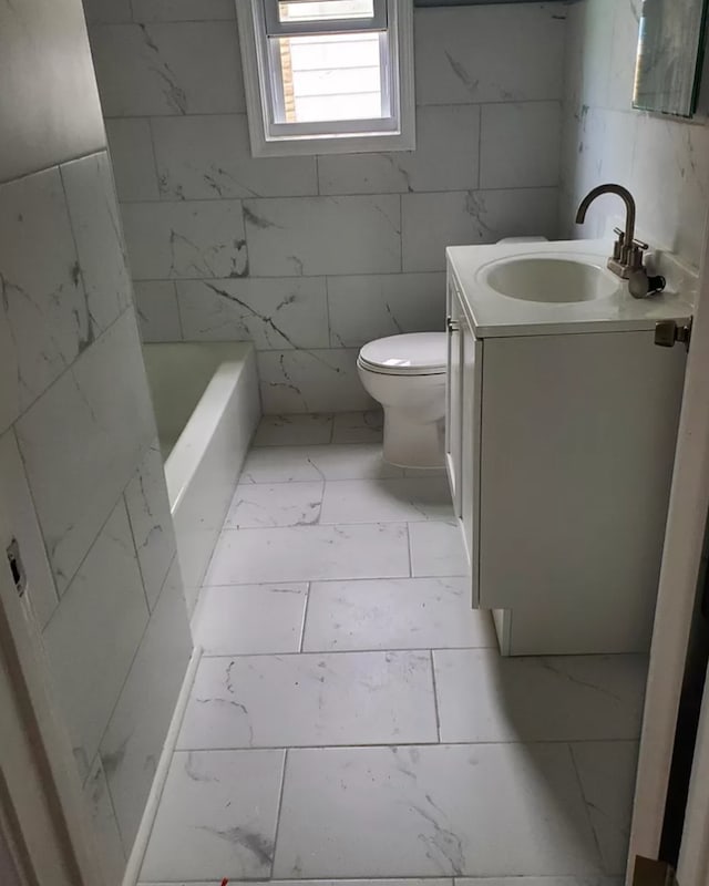 bathroom with vanity, toilet, and a bathing tub