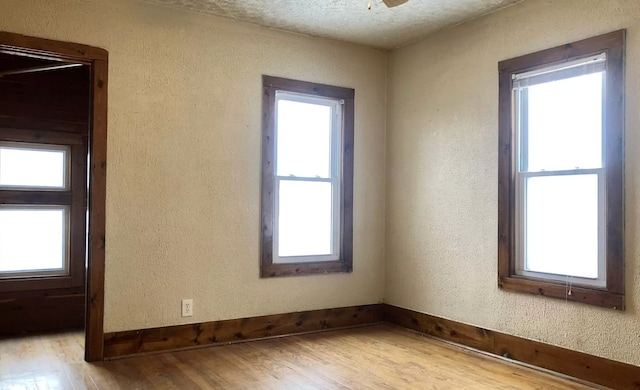 spare room with a wealth of natural light and light wood-type flooring