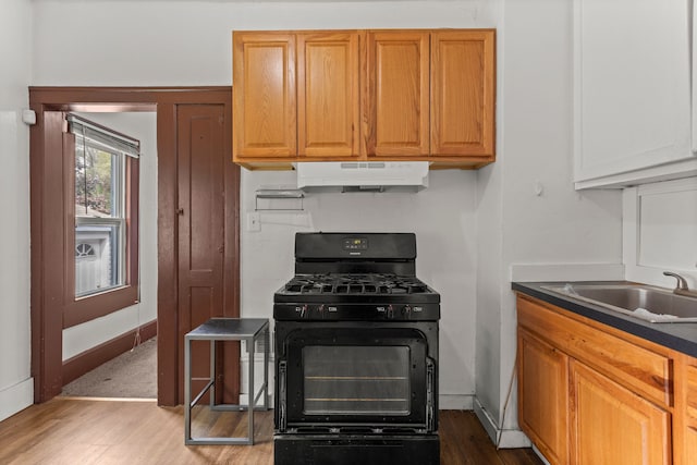 kitchen featuring sink, light hardwood / wood-style flooring, and black gas range oven