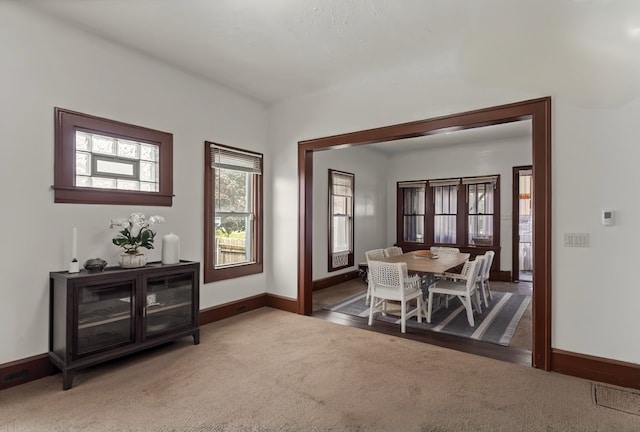 dining room featuring dark colored carpet