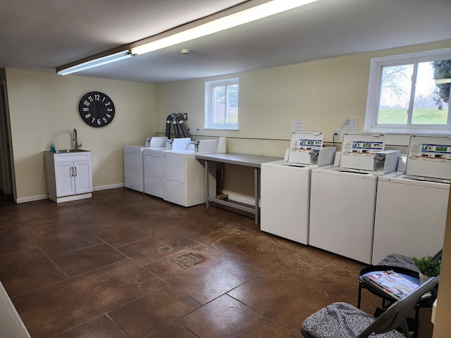 laundry area with cabinets, washing machine and dryer, and sink