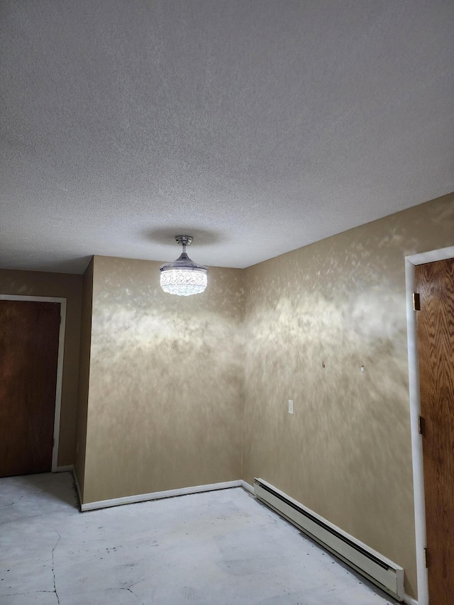 unfurnished room featuring a baseboard radiator and a textured ceiling