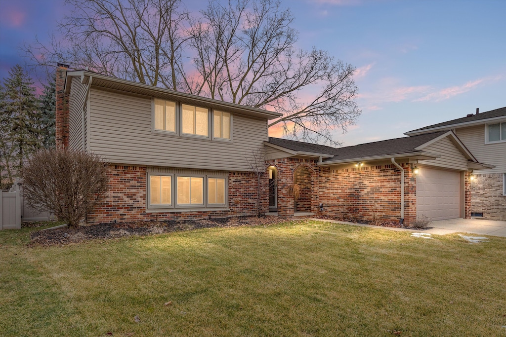 view of front of house featuring a garage and a lawn