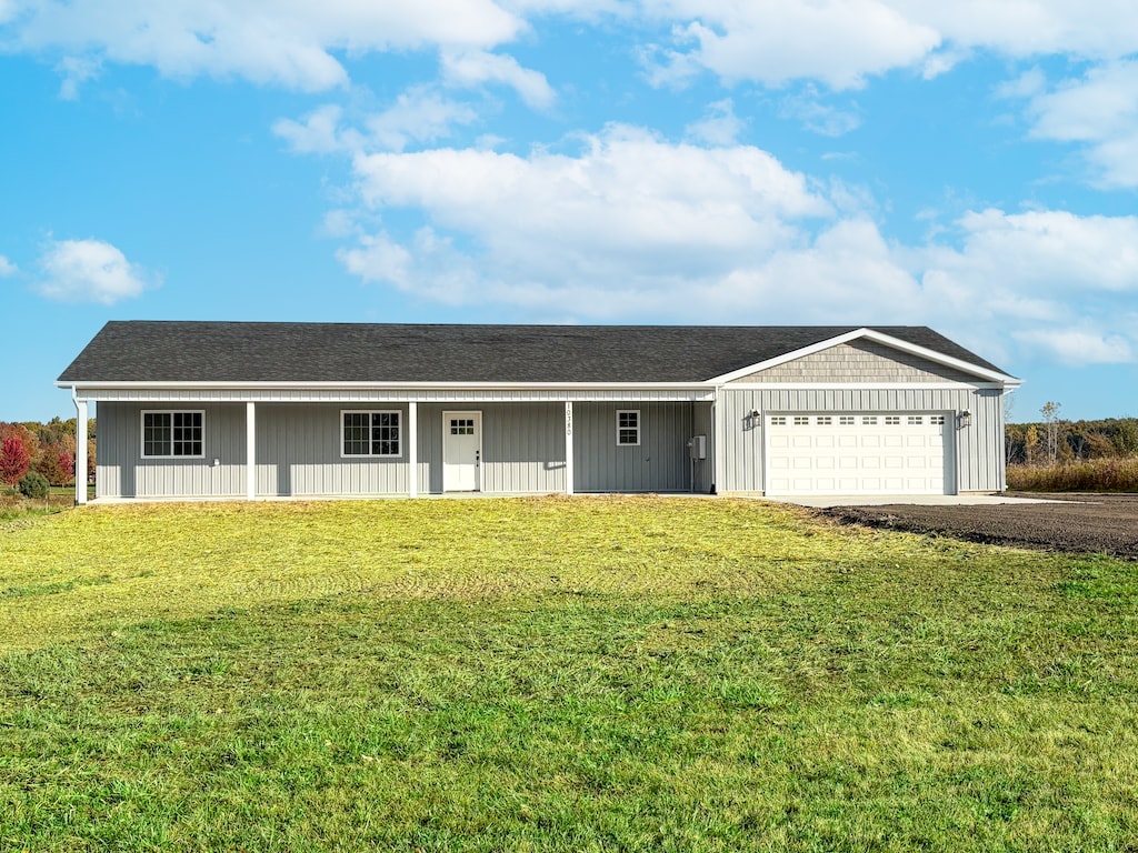 ranch-style house featuring a garage and a front lawn