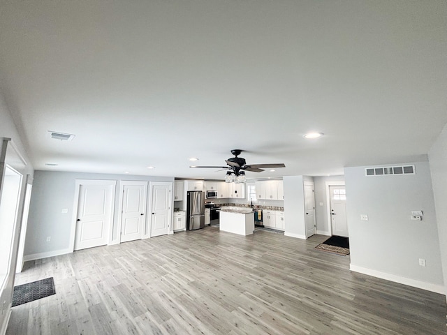 unfurnished living room featuring hardwood / wood-style floors and ceiling fan